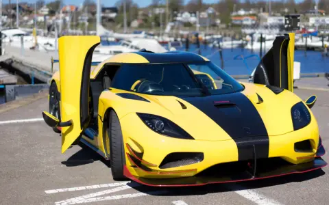 Gelber Koenigsegg Agera RS mit geöffneten Türen am Hafen, bereit für eine Spritztour.