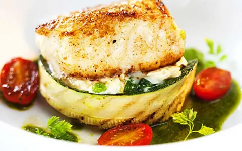 En läcker fiskrätt med grillad zucchini, körsbärstomater och en grön sås. Ett perfekt lubb recept för en fin middag.