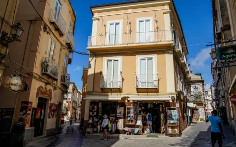 Un vicolo di Tropea con negozietti e palazzi color ocra, un'atmosfera che ricorda la porta vaticana.