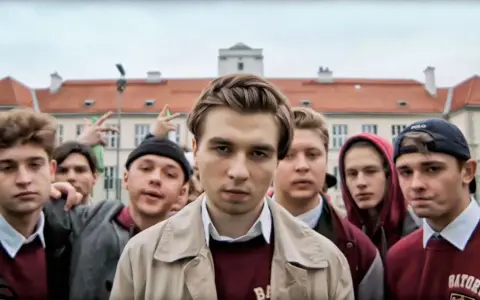Grupa młodych ludzi przed budynkiem liceum. Czy to właśnie do jakiego liceum chodził Mata?