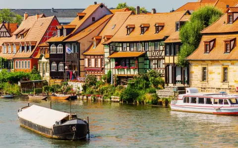 Bunte Fachwerkhäuser säumen das Wasser, Boote schaukeln sanft. Ein malerischer Anblick, der die vielen Attraktionen Bayerns widerspiegelt.