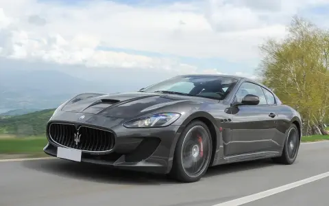 Szary Maserati GranTurismo na krętej drodze. Marzysz o takim aucie? Sprawdź, jaka jest aktualna maserati cena!