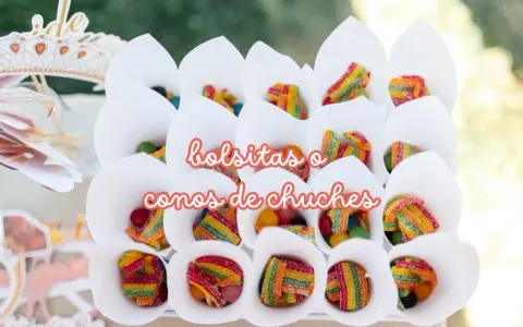 Conos blancos llenos de diferentes tipos de chuches, como gominolas arcoíris y bolitas de colores.