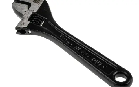 Llave inglesa negra, con marcas de medición en milímetros y la inscripción "HEAVY DUTY". Es una herramienta robusta, como el pie del rey.