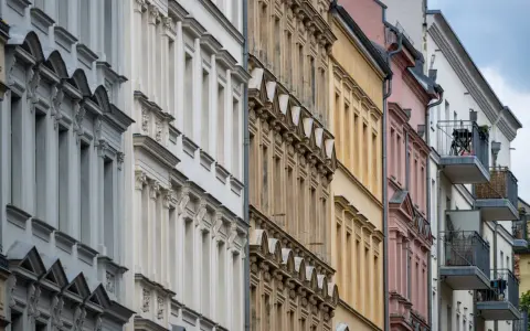 Reihenhausfassaden in verschiedenen Farben, von Grau über Beige bis Rosa. Ein Blick auf den m2 preis wohnung in dieser Gegend.