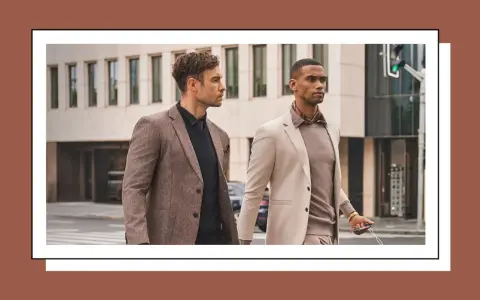 Dos hombres con trajes elegantes caminan por la calle. Uno lleva un traje beige y el otro un traje marrón.