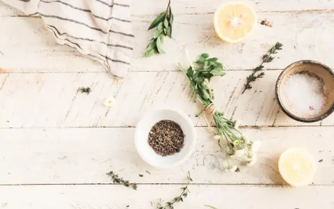 Zutaten für selbstgemachte Kosmetik: Lavendel, Kräuter, Zitrone und Salz auf Holzhintergrund.