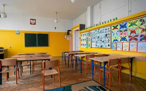 Pusta klasa z kolorowymi pracami dzieci na ścianie. Idealne miejsce, kiedy wolne od szkoły, by poczuć się jak uczeń.