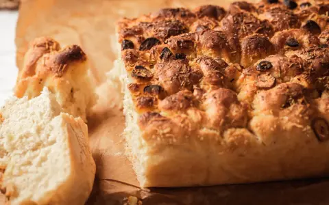 Puszysta focaccia z oliwkami i rozmarynem, idealna do podania. Ten przepis na focaccię jest prosty i szybki.