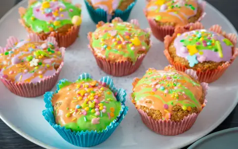 Bunte Karottenmuffins mit Zuckerguss und Streuseln, perfekt für ein Frühlingsfest. Dieses Karottenmuffins Rezept ist ein Hit!