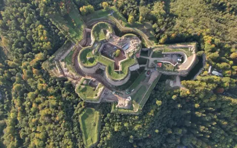 Fortyfikacje z lotu ptaka, otoczone lasem. Srebrna Góra oferuje unikalne atrakcje historyczne, widoczne na tym zdjęciu.
