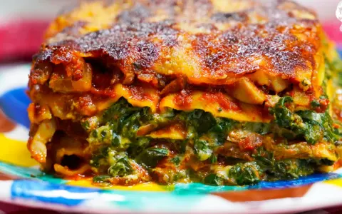 Deliciosa lasaña de verduras, con capas de pasta, espinacas y salsa de tomate, gratinada y dorada.