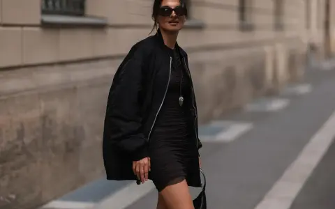 Stylische Frau in schwarzer Bomberjacke und engem Kleid. So kann man eine Bomberjacke kombinieren, Damen!
