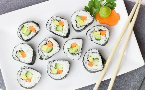 Pyszne futomaki z awokado, ogórkiem i marchewką, podane z wasabi i natką pietruszki.