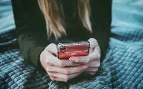 Dziewczyna przegląda profile na Tinderze, szukając dopasowania.