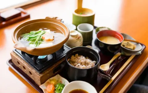Japońskie śniadanie: gorący bulion z warzywami i tofu, ryż, zupa miso i dodatki.