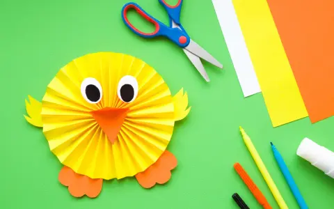 Manualidades para niña de 2 años: un pollito de papel. Tijeras, papeles de colores, rotuladores y pegamento listos para crear.