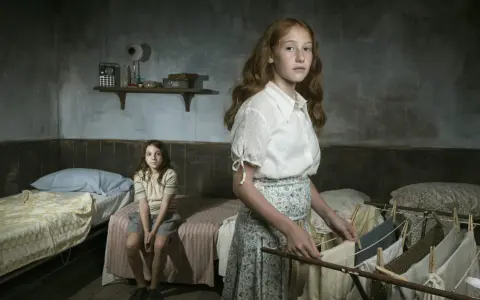 Due bambine in una stanza spartana, una stende il bucato, l'altra siede sul letto. Ricorda l'arminuta storia vera.