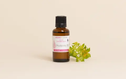 Flacone di Provitamina B5, un attivo cosmetico fortificante e idratante per la pelle, accanto a un rametto fiorito.