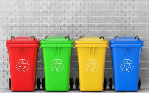 Czerwony, zielony, żółty i niebieski pojemnik na śmieci z symbolem recyklingu. Różne kolory pojemników na śmieci ułatwiają segregację.