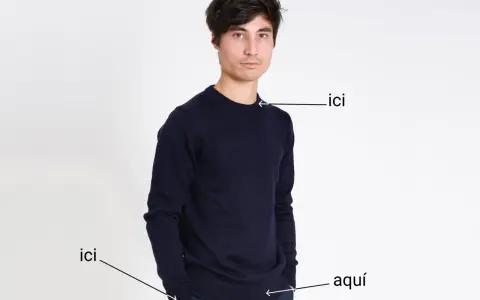 Un homme porte un pull bleu marine. Le tissu pul endroit envers est visible sur le bord du pull.