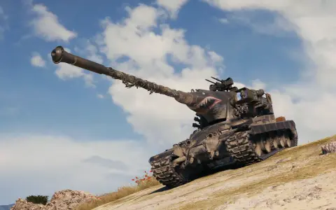 Czołg z malowaniem rekina, jak z modów do World of Tanks, wspina się po piaszczystym wzgórzu pod błękitnym niebem.