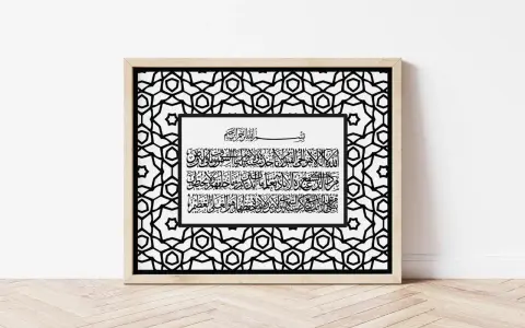 Gerahmte Kalligrafie mit arabischer Schrift auf weißem Hintergrund, umgeben von einem geometrischen Muster. Ein Vers erinnert daran, dass "und wir haben euch in paaren erschaffen".