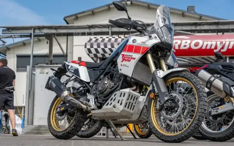Biały motocykl Yamaha Ténéré 700 z czerwonymi akcentami, gotowy na przygodę. Dane techniczne tego modelu zachwycają.