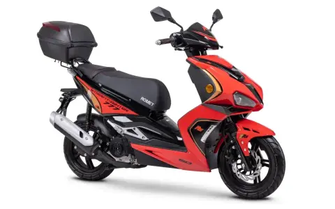 Czerwony skuter z czarnym siedzeniem i kufrem. Do jakiej pojemności można jeździć motorem bez prawa jazdy? Ten model to świetny wybór!