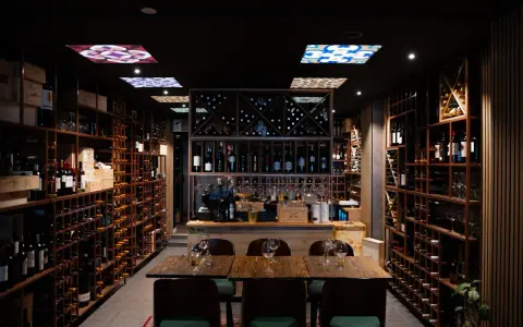 En vinbar med hyllor fyllda med flaskor, redo för en kväll med pasion tapas och goda viner.