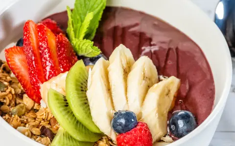 Acai-Bowl mit Erdbeeren, Bananen, Kiwi, Blaubeeren, Himbeeren und Granola. Was ist Acai? Eine gesunde Beere für dein Frühstück!