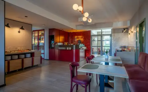 Nowe, stylowe wnętrze z bufetem śniadaniowym i neonem "But first coffee". Idealne miejsce na poranną kawę, zgodnie z licznymi hotel Antares opinie.