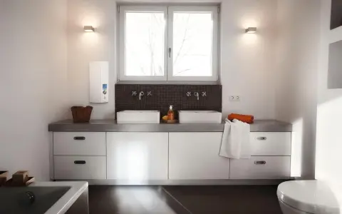 Modernes Badezimmer mit Doppelwaschbecken und einem AEG Durchlauferhitzer 24 kW an der Wand.