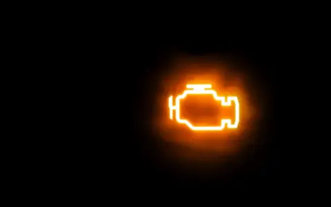 Icona luminosa arancione di un motore su sfondo nero. La spia MIL accesa indica un problema.