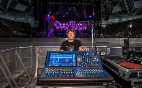 Mężczyzna przy konsolecie Midas, gotowy do obsługi koncertu Deep Purple. Dziedzictwo dźwięku na żywo.