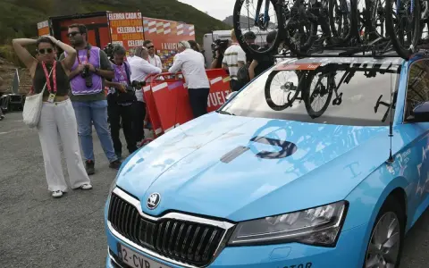 Blaues Auto mit Fahrrädern auf dem Dach, bereit für ein Rennen. Auf der Motorhaube steht "PREMIER TECH", ein Zeichen für israelische Spitzentechnologie im Radsport.