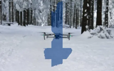 Eine Drohne fliegt über eine verschneite finnische Landschaft. Die Silhouette Finnlands ist über das Bild gelegt.