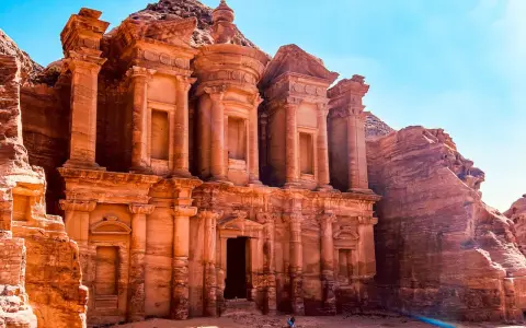 Le Monastère d'Ad-Deir, un trésor de Petra en Jordanie, se dresse majestueusement sculpté dans la roche ocre sous un ciel bleu éclatant.
