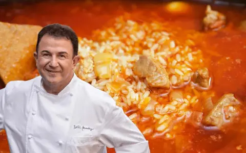 Chef Dani García sonríe junto a un plato de arroz meloso con trozos de atún y carne.