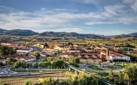 Vista aérea de un pueblo con tejados rojos y montañas al fondo. Se ve la bodega RODA, un buen lugar para añada 2017 rioja.