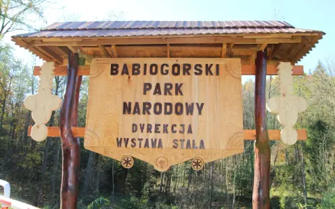 Drewniana brama z napisem "Babiogórski Park Narodowy" zaprasza do odkrywania **zawoja atrakcje**.