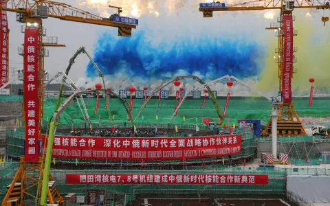 Bau von China Atomkraft-Anlagen mit Kränen und bunten Rauchsäulen. Chinesische und russische Banner feiern die Zusammenarbeit.