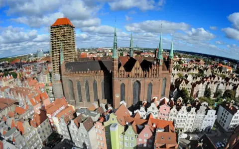 Widok z lotu ptaka na Bazylikę Mariacką w Gdańsku i kolorowe kamienice Starego Miasta.