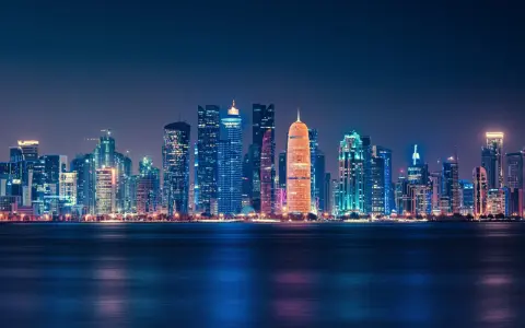 Glitzernde Skyline von Doha bei Nacht, ein Symbol für das moderne Katar.