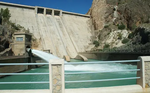 El embalse del Cenajo libera agua a través de un gran conducto, creando una cascada espumosa en el río.