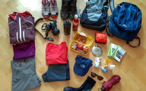Packliste Mehrtagswanderung: Wanderschuhe, Rucksäcke, Kleidung, Kamera, Verpflegung, Trinkflasche, Sonnenbrille, Regenschirm und Wanderkarten.