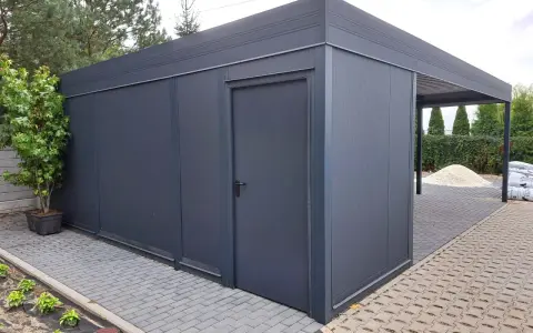 Nowoczesny garaż z wiatą, idealny na działkę bez pozwolenia. Elegancki, ciemnoszary, z praktycznymi drzwiami i zadaszeniem.
