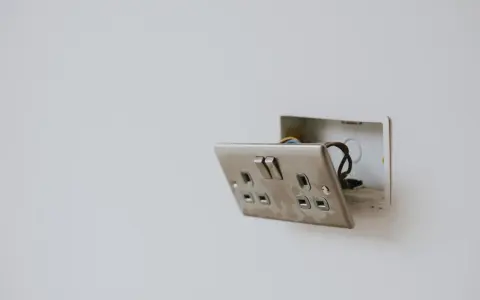 Enchufe con interruptor abierto, mostrando cables. Guía visual para como conectar un enchufe interruptor y bombilla.