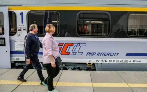 Para podróżuje obok pociągu PKP Intercity, który może zabrać ich z Rzeszowa do Krakowa.