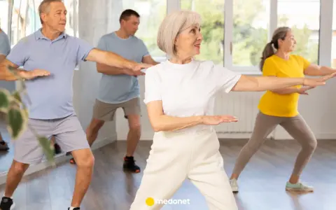 Seniorzy ćwiczą tai chi na krześle, poprawiając równowagę i spokój.